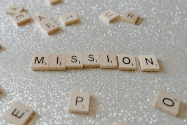 pexels photo 7666429 7666429 Scrabble tiles spelling 'Mission' on a sparkling surface convey determination and goals.